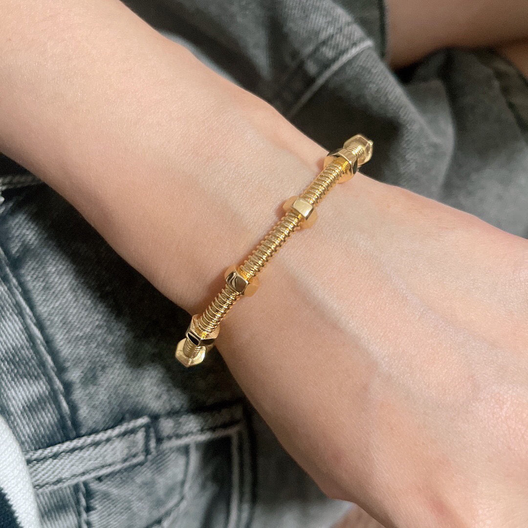 Gold flexible screw bangle worn on wrist